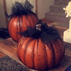 two pumpkins sitting on top of a wooden table