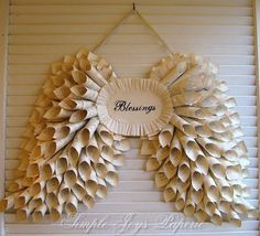 a wreath made out of book pages with the word blessing written on it, hanging on a wall