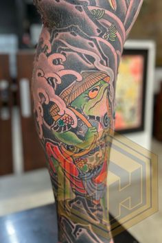 a man's leg with tattoos on it and an image of a dragon in the background