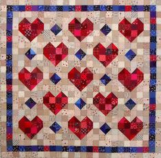 a quilt with hearts on it is shown in red, white and blue colors scheme