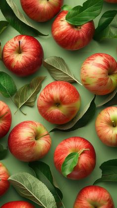 many apples with leaves on them are arranged in a pattern