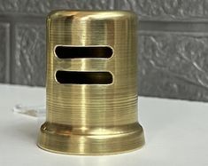 a gold metal object on a white table