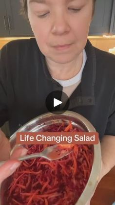 a woman is holding a bowl of spaghetti