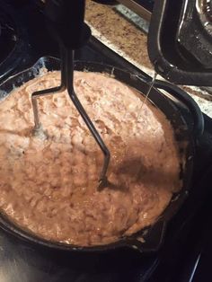 a pan with some food cooking on top of it in the oven and being stirred by a whisk