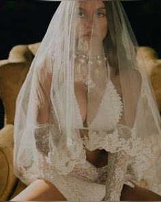 a woman wearing a veil and dress sitting on a couch