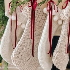 christmas stockings hanging from a mantel decorated with pom - poms