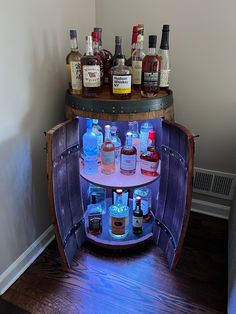 a wooden barrel filled with liquor bottles on top of a table