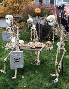 three skeletons are standing in front of a table with a sign that says, no one dead now