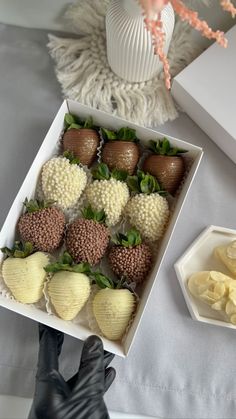 a box filled with chocolate covered strawberries next to sliced bananas and other fruit items