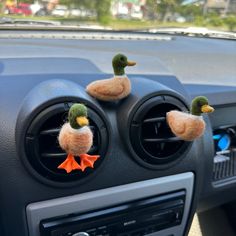 two ducks sitting on the dashboard of a car