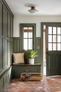 an entryway with green painted doors and brick flooring is pictured in this image