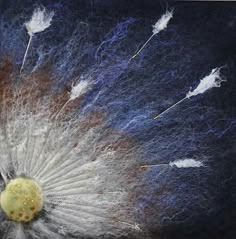 a dandelion with white feathers and blue background