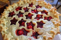 a pie with cherries on it sitting on a counter