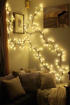 a living room with lights on the wall and a couch in front of it's headboard