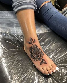 a woman's foot with a rose tattoo on her left side and the bottom part of her leg