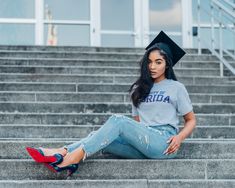 a woman sitting on steps wearing a cap and jeans