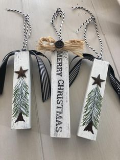 three wooden christmas tags hanging from twine with ribbon and star decorations on them,