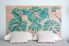 the headboard is made out of wood and has green leaves on it