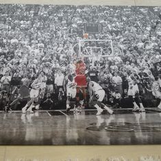 an old photo of a basketball game being played in front of a large group of people