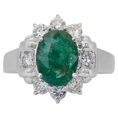 Glamorous 2.66ct Emerald and Diamonds Cluster Ring in 18k White Gold - IGI Certified Experience the enchanting allure of this magnificent emerald and diamond cluster ring. The centerpiece is a breathtaking 2.03-carat oval emerald, radiating a vibrant green hue that symbolizes luxury and elegance. This striking gemstone is elegantly accented by 8 round diamonds, totaling 0.63 carats, adding a touch of sparkling brilliance. This exquisite ring is certified by IGI, assuring its exceptional quality Modern Ring, Emerald Stone, Ruby Diamond, Diamond Cluster Ring, Vibrant Green, Emerald Diamond, Brilliant Diamond, Diamond Cluster, Cluster Ring