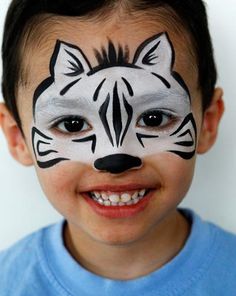 a young boy with his face painted like a zebra