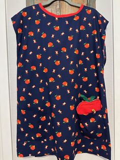 a blue top with oranges and stars on it is hanging from a wooden door