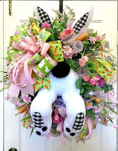 a wreath with a stuffed animal hanging on the front door