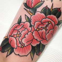 a close up of a flower on a person's leg with tattoos in the background