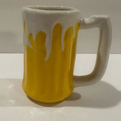 a yellow and white mug sitting on top of a table