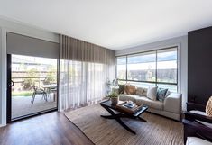 a living room filled with furniture next to a sliding glass door that opens onto a patio