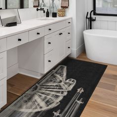 a bathroom with a bathtub, sink and large rug on the floor in front of it