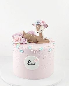 a pink cake decorated with flowers and a deer