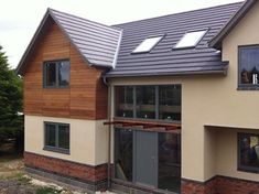 a house that has some windows on the side of it and is being built with wood