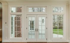 the inside of a house with double doors and brick wall in the back ground area