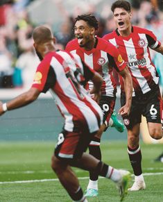 two soccer players are running on the field and one is holding his mouth wide open