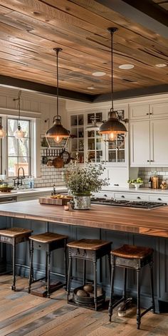 a kitchen with an island and stools in front of the counter top, surrounded by wooden flooring