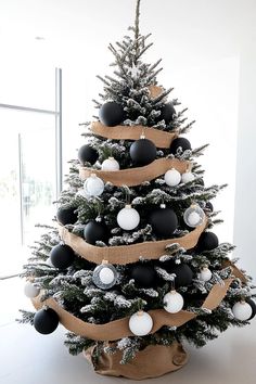 a decorated christmas tree with black and white ornaments on it's top, in a room