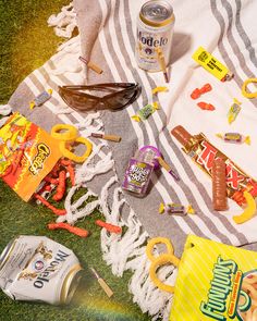 the contents of a picnic blanket laid out on the grass next to an open can of soda