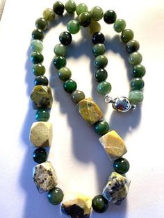 ANTIQUE TOP QUALITY ORIGINAL GREEN JADE Round Beads make up the Body of this necklace.. I have added SEVEN Rectangular/Square Cut Large Unusual SERPENTINE Beads in the center as a Feature and for weighting towards the HEART CHAKRA... This makes for a really Unusual Necklace... Not the standard JADE, Dark Green and TOP QUALITY Round Beads ... A sliver Magnetic clasp holds it together. Feels AMAZING on the skin... A very HEALING Necklace On a physical level, GREEN JADE has a powerful and calming vibration that's also highly protective.. SERPENTINE is associated with the Heart Chakra. This green stone can assist with healing problems within the heart and lungs, boost energy, and it is an excellent stone for cellular regeneration. ~ Aurana ~ https://auranaspiritualjourneys.com Rectangular Green Beaded Necklace For Gift, Green Rectangular Beaded Necklace Gift, Green Gemstone Beads For Gifts, Green Beaded Rectangular Necklace, Handmade Green Rectangular Necklace, Green Rectangular Beaded Necklace, Beaded Round Green Emerald Necklace, Unique Hand-strung Green Beaded Necklaces, Green Rectangular Gemstone Beads Jewelry