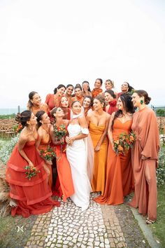 a group of women standing next to each other in front of a field with flowers