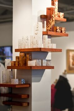 two wooden shelves with glass vases on them