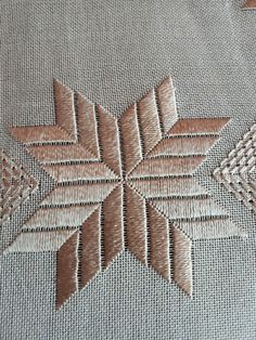 a close up view of an embroidered design on a piece of cloth with stitching