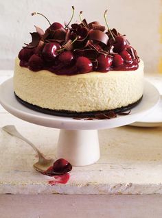 a cake with cherries on top is sitting on a plate