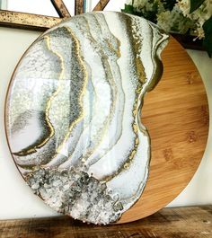 a wooden plate sitting on top of a table next to a vase filled with flowers