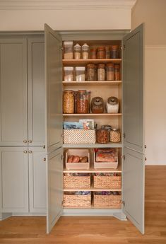 an open pantry with lots of containers and baskets on the shelves in front of it