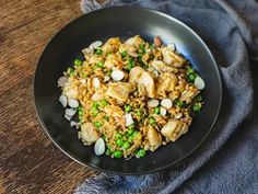 a black plate topped with rice and peas