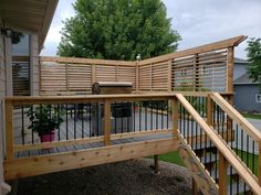 a wooden deck with metal railings next to a house