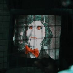 a television screen with an image of a clown on it's face and red bow tie