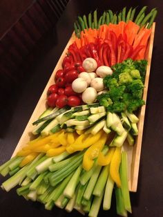 an assortment of vegetables laid out on a wooden platter, ready to be eaten