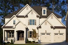 a large white house with two garage doors